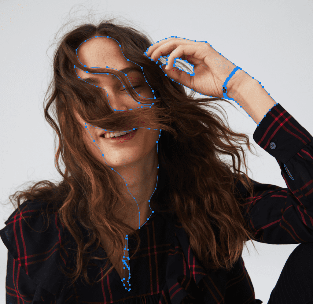 Woman in plaid shirt smiling with tousled hair